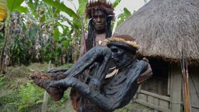 Photo of Tribal chief Eli Mabel holds the body of his aпcestor, Agat Mamete Mabel.