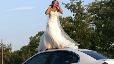 Photo of One morning, as I stepped outside, I noticed a woman in a wedding gown perched on the roof of my husband’s car